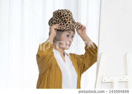 Senior women choosing hats and dressing stylishly Senior women choosing hats and dressing stylishly 143084899