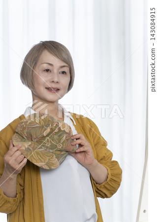 老年婦女挑選帽子和穿著時尚 老年婦女挑選帽子和穿著時尚 143084915