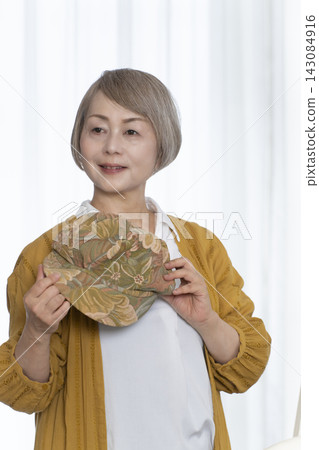 老年婦女挑選帽子和穿著時尚 老年婦女挑選帽子和穿著時尚 143084916