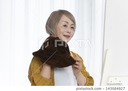 老年婦女挑選帽子和穿著時尚 老年婦女挑選帽子和穿著時尚 143084927