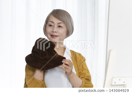 Senior women choosing hats and dressing stylishly Senior women choosing hats and dressing stylishly 143084929