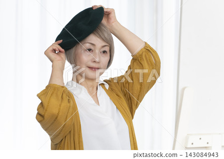 老年婦女挑選帽子和穿著時尚 老年婦女挑選帽子和穿著時尚 143084943