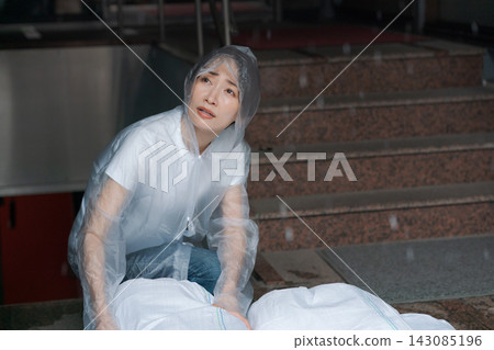 一名婦女正在堆放沙袋，為防洪做準備。 143085196