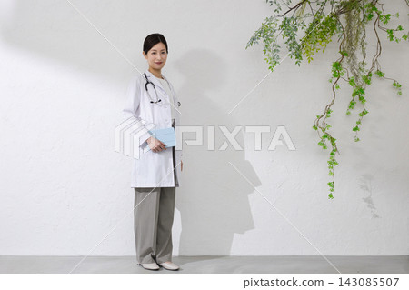 Female doctor wearing white coat Female doctor wearing white coat 143085507