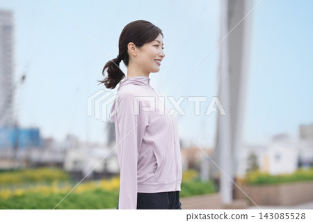 中年婦女身穿運動服伸展身體 中年婦女身穿運動服伸展身體 143085528