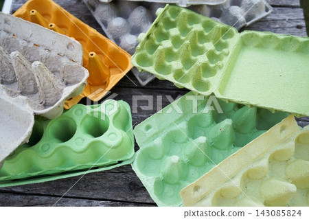 Assorted cardboard egg boxes collection on rustic wooden background layout Assorted cardboard egg boxes collection on rustic wooden background layout 143085824