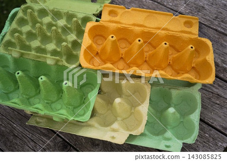 Empty protective pressed cardboard packaging for eggs on wooden texture backdrop Empty protective pressed cardboard packaging for eggs on wooden texture backdrop 143085825