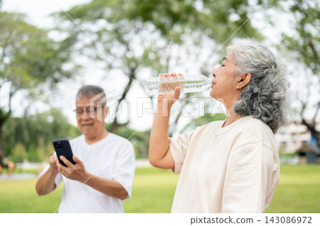 Senior Woman Drinking Water Man Phone Outdoor Park. Senior Woman Drinking Water Man Phone Outdoor Park. 143086972