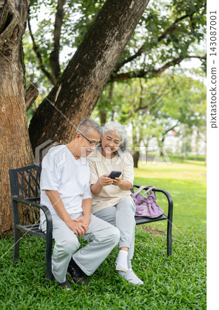 Senior Couple Sharing Phone Bench Outdoor Park. Senior Couple Sharing Phone Bench Outdoor Park. 143087001