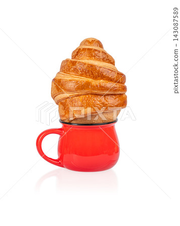 Croissant pastry placed on top of a red ceramic coffee cup, showcasing a unique food presentation with a glossy finish and vibrant color contrast Croissant pastry placed on top of a red ceramic coffee cup, showcasing a unique food presentation with a glossy finish and vibrant color contrast 143087589