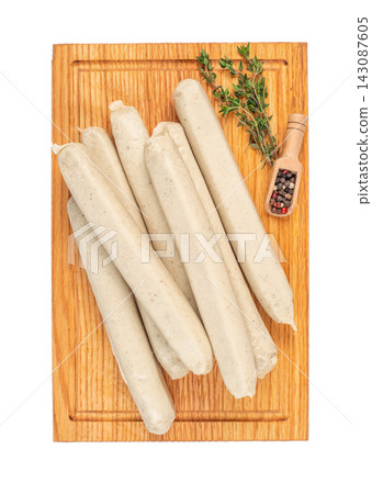 Raw sausages arranged on a wooden cutting board with fresh thyme and a small scoop of mixed peppercorns for seasoning and culinary preparation Raw sausages arranged on a wooden cutting board with fresh thyme and a small scoop of mixed peppercorns for seasoning and culinary preparation 143087605