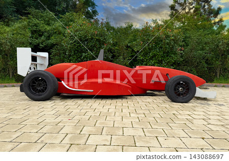 The car has large black tires and a distinct rear wing. The car has large black tires and a distinct rear wing. 143088697