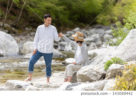 一對情侶在河邊牽手。 143089442