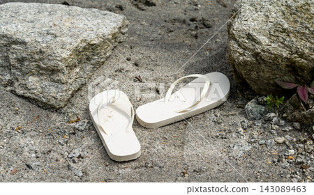 White flip-flops placed on the sandy beach White flip-flops placed on the sandy beach 143089463