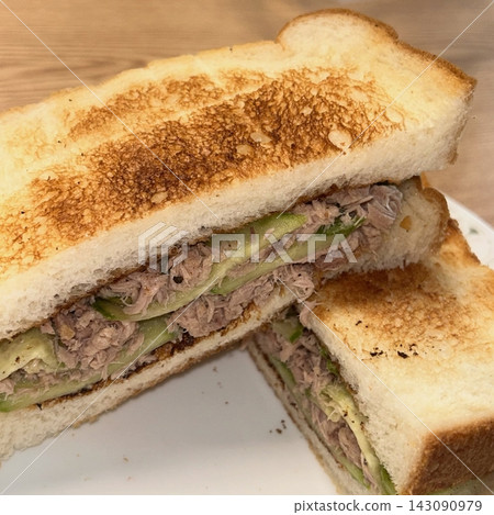 A delicious sandwich with layers of fresh ingredients like lettuce, tomato, cheese, and deli meats, all stacked between two slices of soft bread. Perfect for a quick and satisfying meal. A delicious sandwich with layers of fresh ingredients like lettuce, tomato, cheese, and deli meats, all stacked between two slices of soft bread. Perfect for a quick and satisfying meal. 143090979
