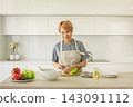 Smiling woman with olive oil in glass jar and organic vegetable on table in kitchen at home.  143091112