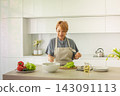 Pretty senior woman chopping and cutting vegetable,  making breakfast. Preparation, cookery  143091113