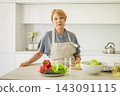 Indoor portrait of female person with healthy food in kitchen. Woman 60 years old 143091115