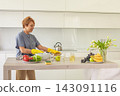 Senior woman wearing yellow rubber gloves wiping in kitchen, indoor portrait 143091116