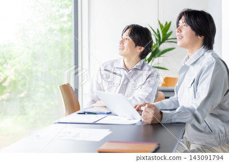 日本男工們正在開會,同時審閱文件。 日本男工們正在開會,同時審閱文件。 143091794