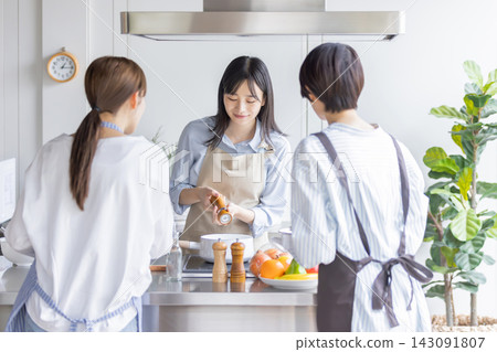 A Japanese woman teaches cooking by adding seasonings during a cooking class. A Japanese woman teaches cooking by adding seasonings during a cooking class. 143091807