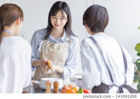 一位日本女性在烹飪課上透過添加調味料來教授烹飪技巧。 143091808