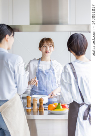 A Japanese woman demonstrating and explaining cooking techniques in a cooking class. A Japanese woman demonstrating and explaining cooking techniques in a cooking class. 143091817
