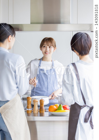 A Japanese woman demonstrating and explaining cooking techniques in a cooking class. A Japanese woman demonstrating and explaining cooking techniques in a cooking class. 143091818