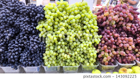 Multicolored grape milk mushrooms at the market. White, red and dark grape harvest Multicolored grape milk mushrooms at the market. White, red and dark grape harvest 143092225