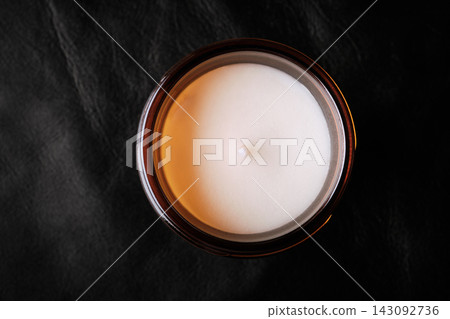 Unlit white wax candle in an amber glass jar, promoting cozy aromatherapy and relaxation Unlit white wax candle in an amber glass jar, promoting cozy aromatherapy and relaxation 143092736
