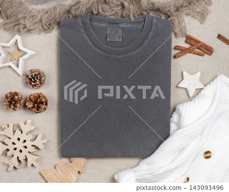 Washed grey t-shirt mockup near rustic Christmas decor, top view with copy space. Holiday template Washed grey t-shirt mockup near rustic Christmas decor, top view with copy space. Holiday template 143093496