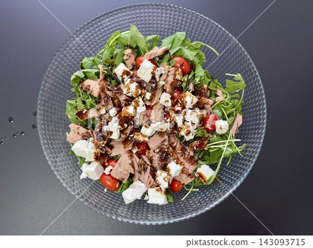 Fresh Mediterranean salad with arugula tuna cherry tomatoes feta cheese and balsamic glaze in glass bowl. Healthy nutrition and organic gourmet dining concept Fresh Mediterranean salad with arugula tuna cherry tomatoes feta cheese and balsamic glaze in glass bowl. Healthy nutrition and organic gourmet dining concept 143093715