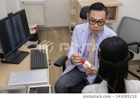 male doctor in a white coat explaining medication and prescription details to a female patient  143095218
