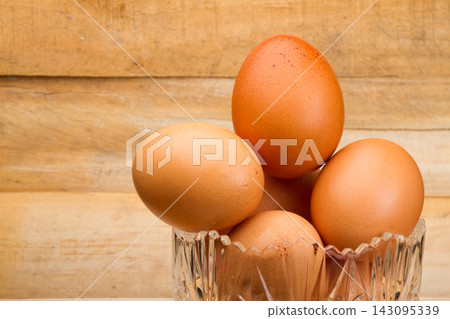 chicken eggs stacked on the wooden table chicken eggs stacked on the wooden table 143095339