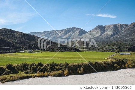 Autumn landscape of mountains with agricultural farming fields, hills, a dry river, and forests Autumn landscape of mountains with agricultural farming fields, hills, a dry river, and forests 143095505