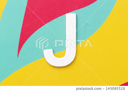 Letter J of the alphabet on colored background, top view Letter J of the alphabet on colored background, top view 143095528