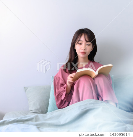 一個女人在床上看書 143095614