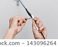 a close-up of a man connecting a ceiling light 143096264