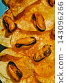glossy mussels on escabeche-soaked potato chips 143096266