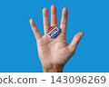a vote badge on the open palm of a man 143096269