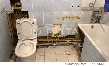Demolished bathroom during renovation works with exposed pipes and old tiles. Horizontal shot Demolished bathroom during renovation works with exposed pipes and old tiles. Horizontal shot 143096689