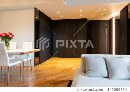 Contemporary living and dining area with Iroko parquet and dark entrance hall Contemporary living and dining area with Iroko parquet and dark entrance hall 143096834