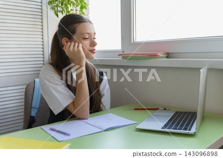 Tired High School Student Studying Online with Laptop Tired High School Student Studying Online with Laptop 143096898