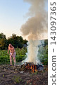 Man burning garden waste in field during agricultural work 143097365