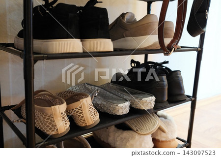 Black and beige shoes neatly stored on a metal rack shelf at home Black and beige shoes neatly stored on a metal rack shelf at home 143097523