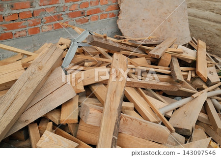 Pile of scrap wooden boards at a construction site during the day Pile of scrap wooden boards at a construction site during the day 143097546