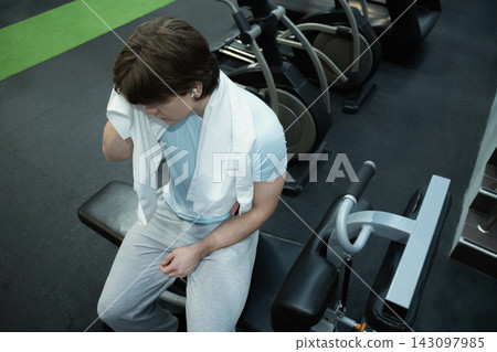 Resting man gym recovery moment. Workout Routine at Gym Resting man gym recovery moment. Workout Routine at Gym 143097985