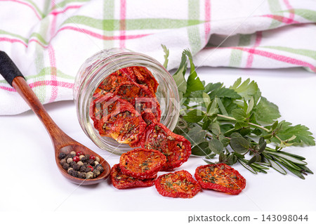 Dried tomatoes in a jar, bunch of parsley and peppercorn. Dried tomatoes in a jar, bunch of parsley and peppercorn. 143098044