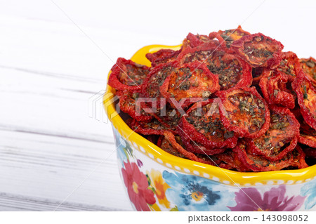 Bowl with dehydrated red fragrant tomatoes with herbs and spices. Bowl with dehydrated red fragrant tomatoes with herbs and spices. 143098052