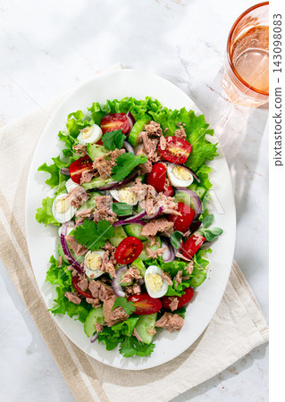 salad with canned tuna, cherry tomatoes, cucumber, and quail eggs on a white plate salad with canned tuna, cherry tomatoes, cucumber, and quail eggs on a white plate 143098083